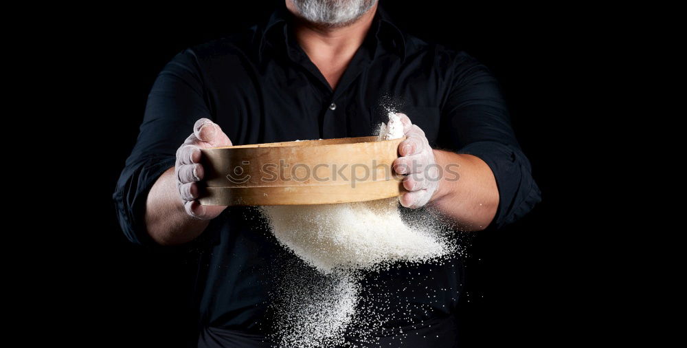 Similar – man sifts white wheat flour through a wooden sieve