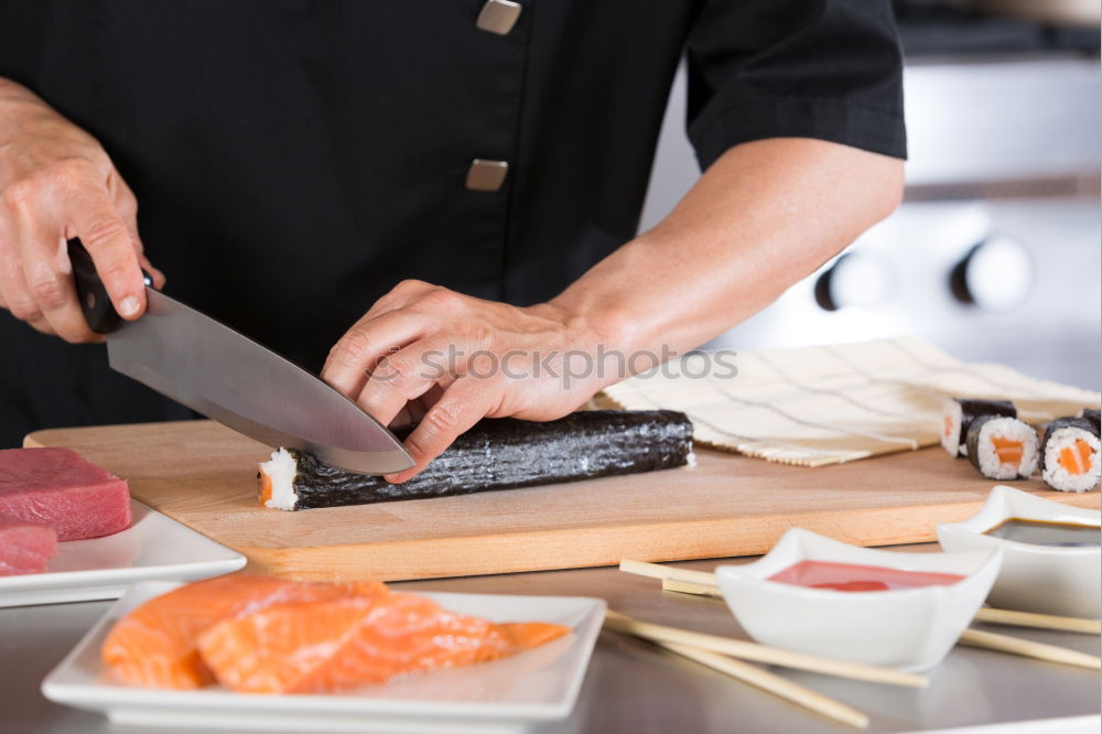 Similar – Closeup of woman chef cutting japanese sushi roll