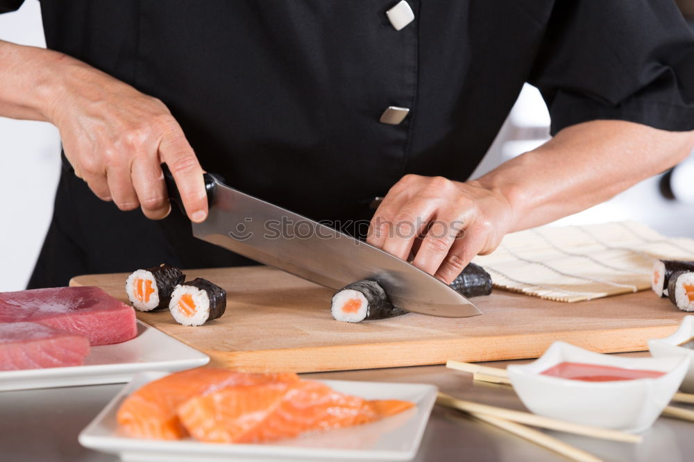 Similar – Closeup of woman chef cutting japanese sushi roll