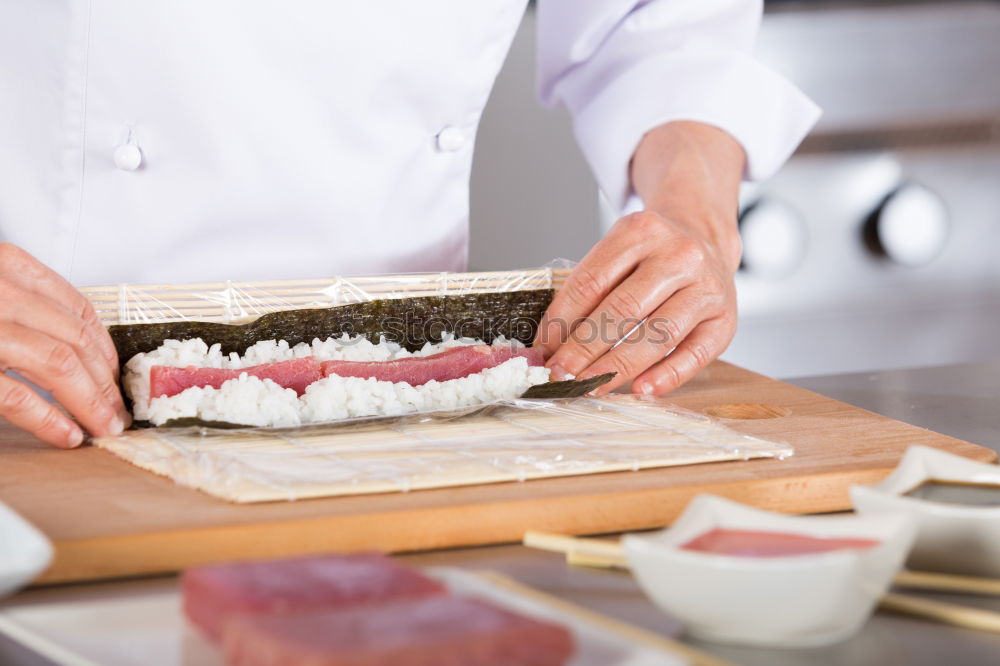 Similar – Woman chef hands rolling up japanese sushi