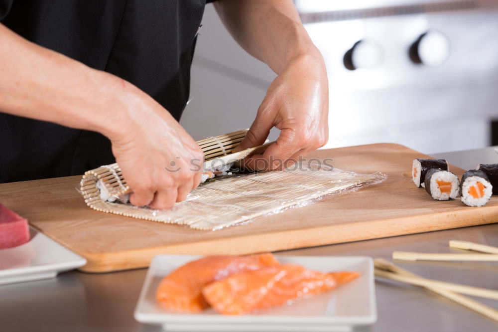 Similar – Woman chef hands rolling up japanese sushi