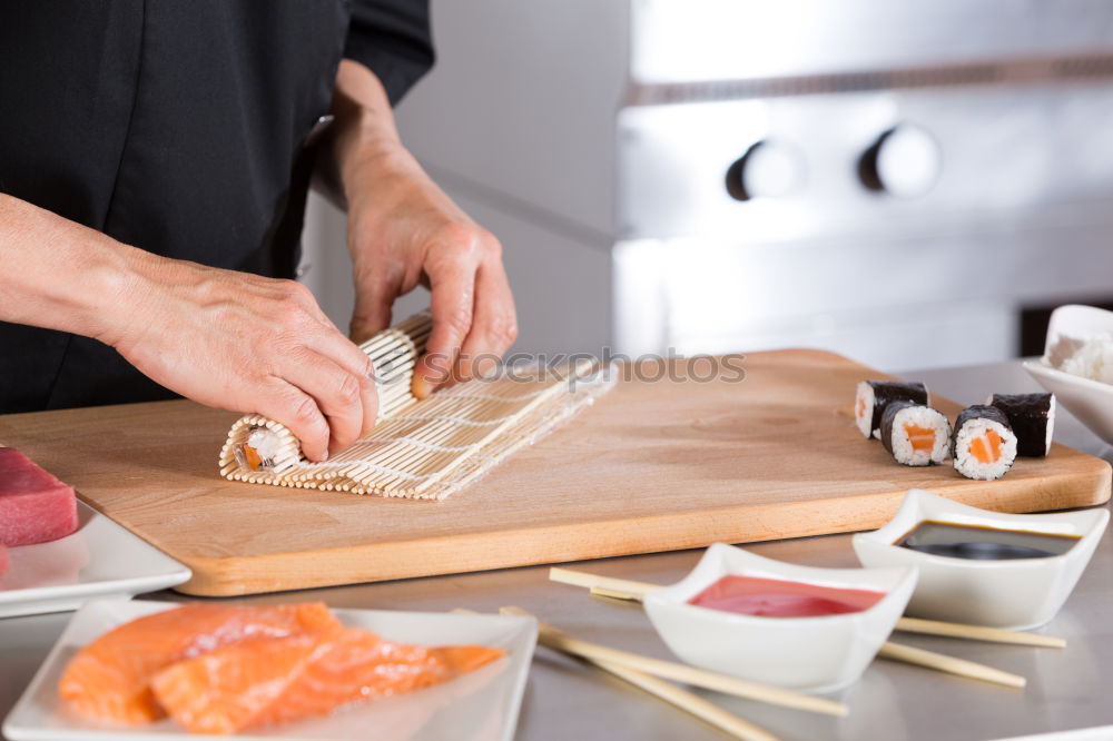 Similar – Closeup of woman chef cutting japanese sushi roll