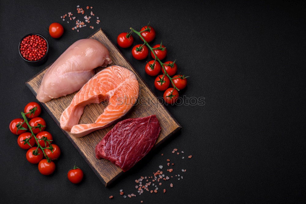 Similar – Salmon fish fillets on chopping board with fresh vegetables