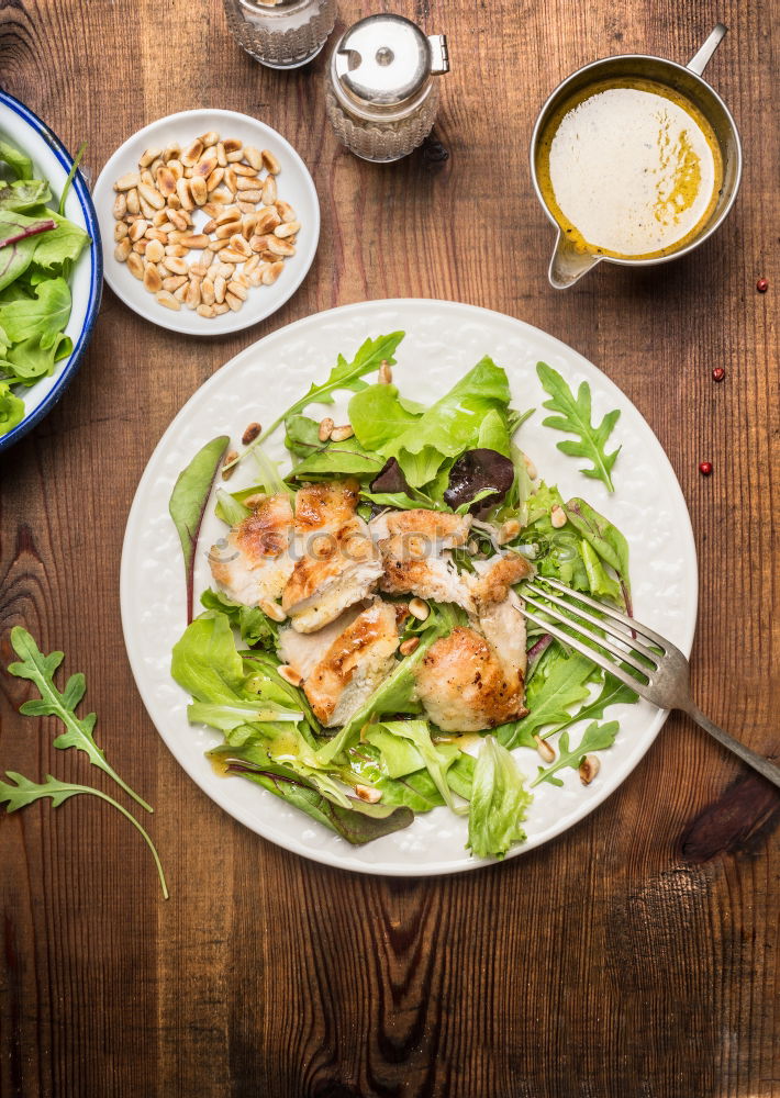 Similar – Healthy green salad with dressing on dark background