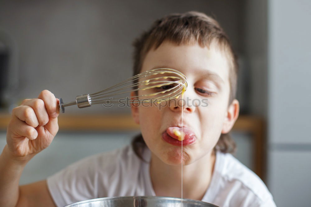 Similar – Little boy in a cafe during lunch. Hungry kid eating sausage from his sandwich