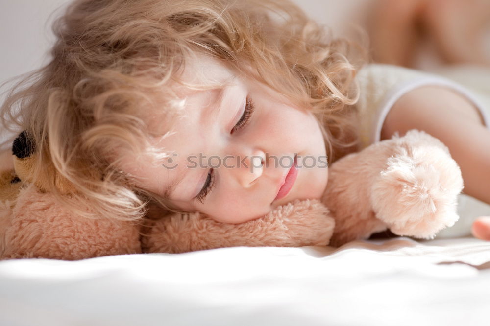 Similar – Little girl lying in a bed with teddy bear at the morning