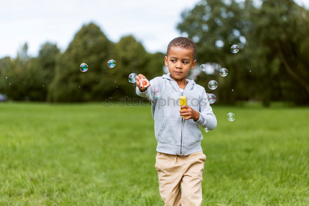 Similar – Image, Stock Photo Happy boy playing with soap bubbles in the park