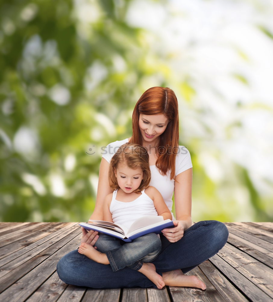 Similar – Mom reading a book her little daughter