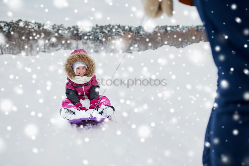 Similar – Mother is playing with her little daughter outdoors on wintery day. Woman is throwing snow on her child. Family spending time together enjoying wintertime. Woman is wearing red coat and wool cap, toddler is wearing dark blue snowsuit