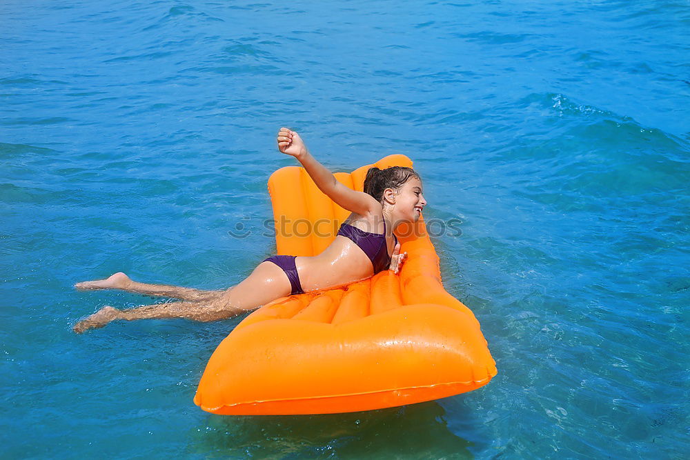 Similar – Woman swimming underwater in blue sea