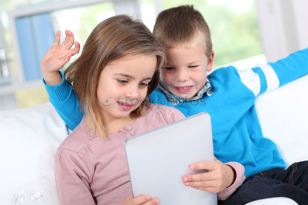 Three kids using a tablet at home