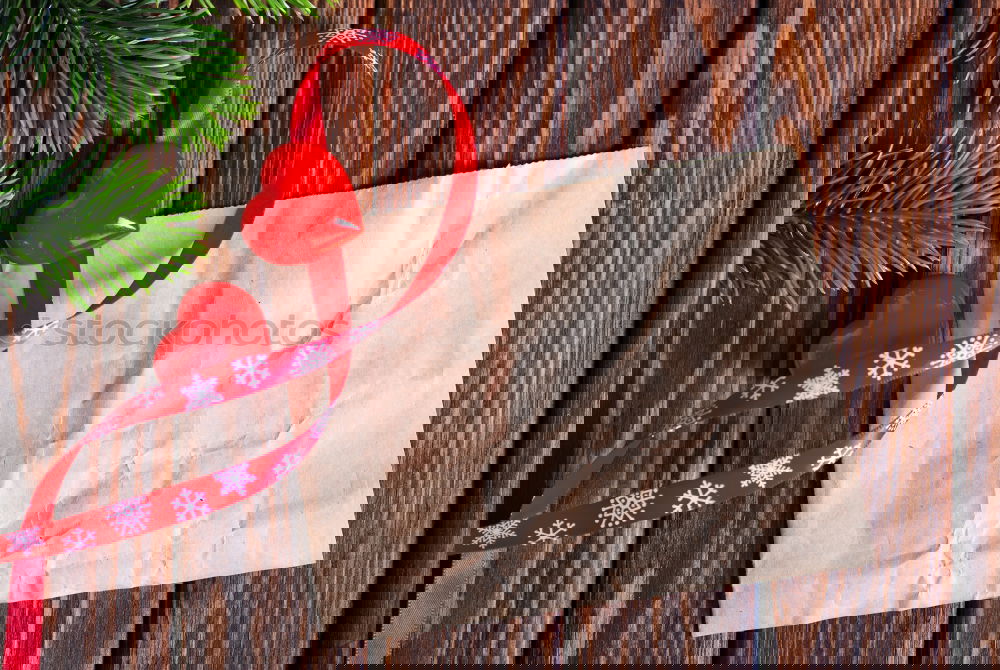 Foto Bild Papiertüte mit hölzernem Tannenbaum-Anhänger vor dunklem Hintergrund