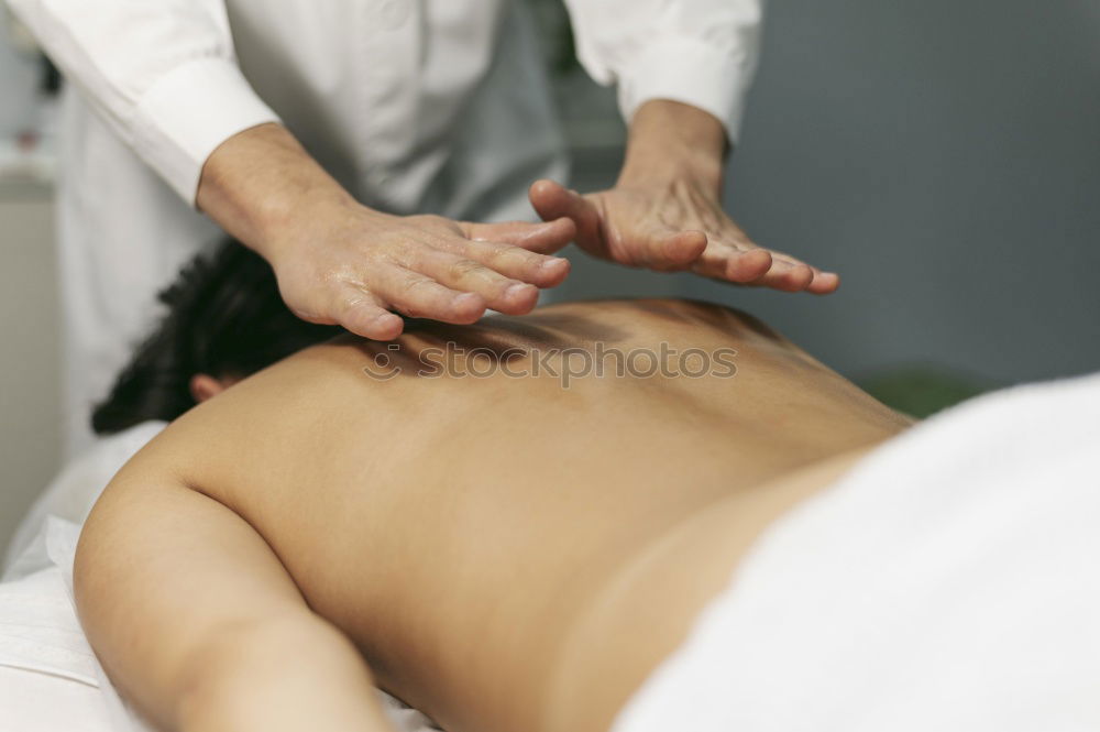 Similar – Woman at beauty spa getting a procedure with hot stones while massage therapist doing arm massage