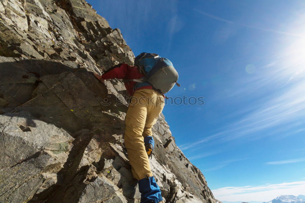 Similar – Climber helps another climber to reach the top of a mountain