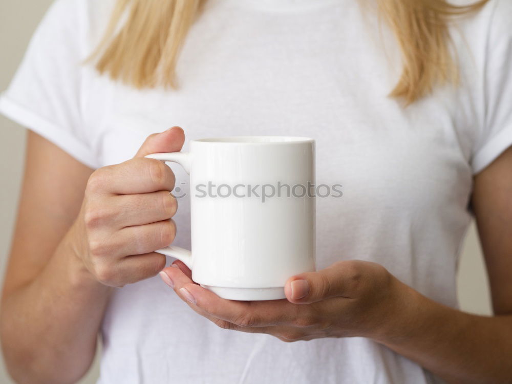 Happy young woman holding a cup of tea or coffee