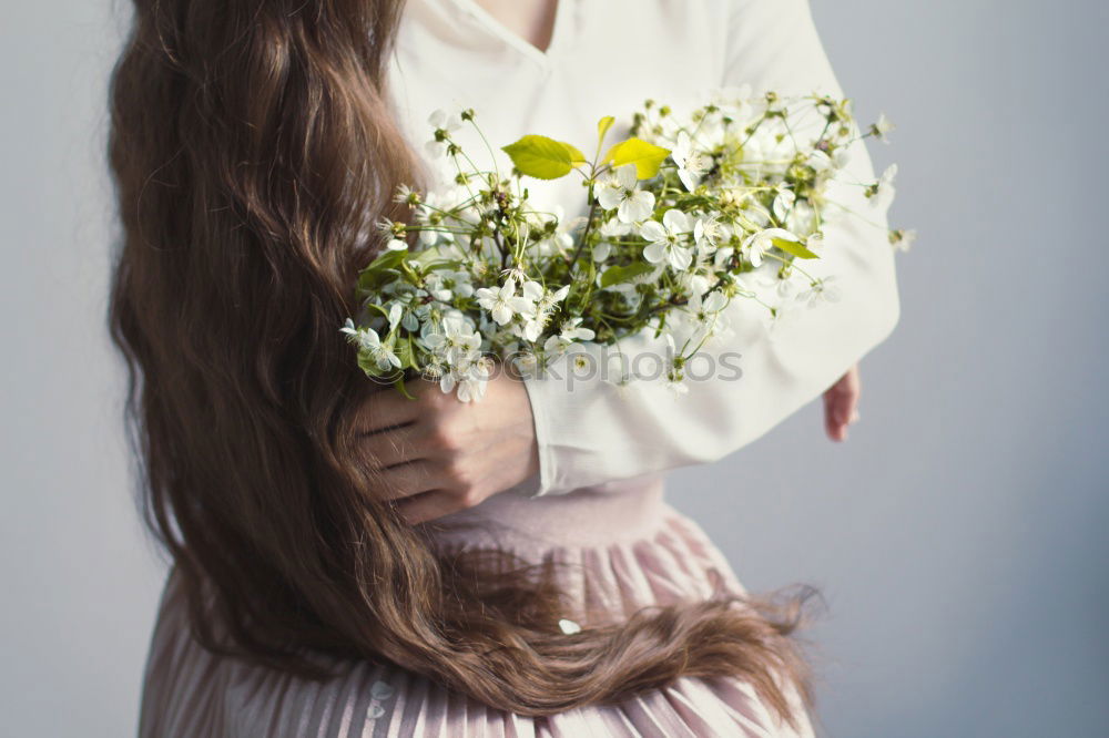 Young woman hugging a bouquet of flowers