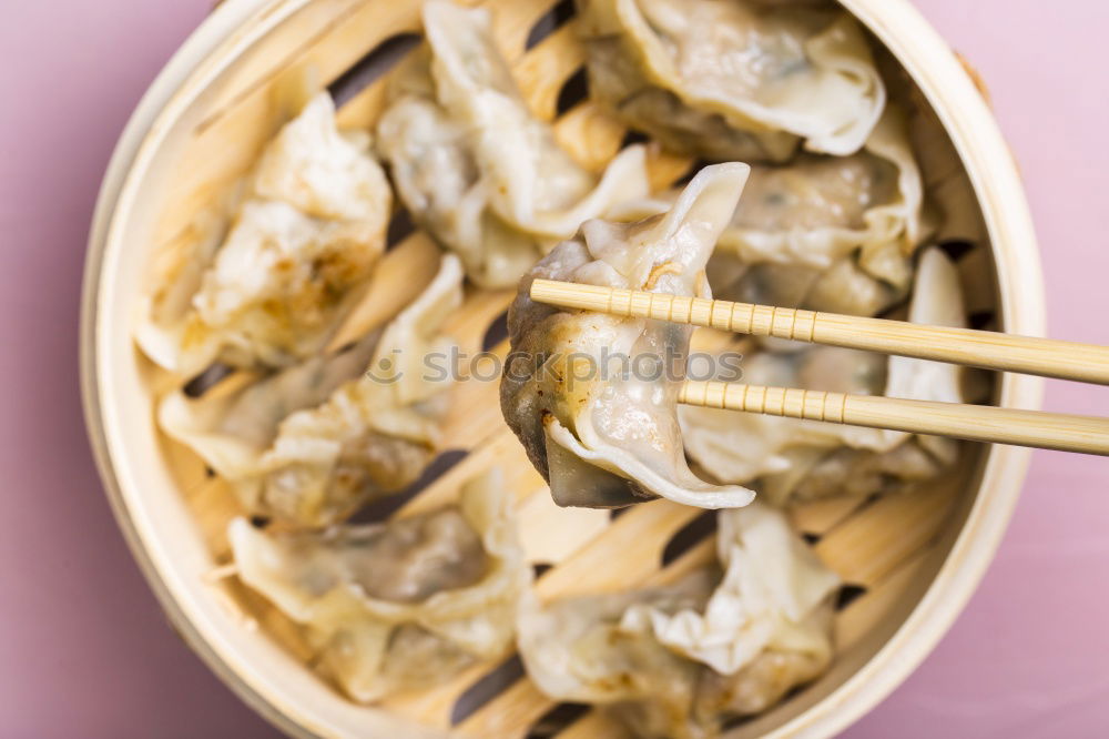 Similar – Dumplings or gyoza served in traditional steamer