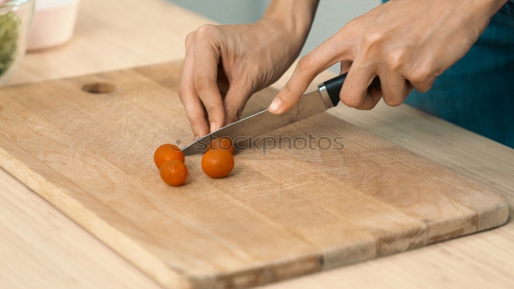 process of cutting slices of carrot on a kitchen board