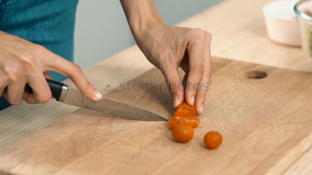 Similar – process of cutting slices of carrot on a kitchen board