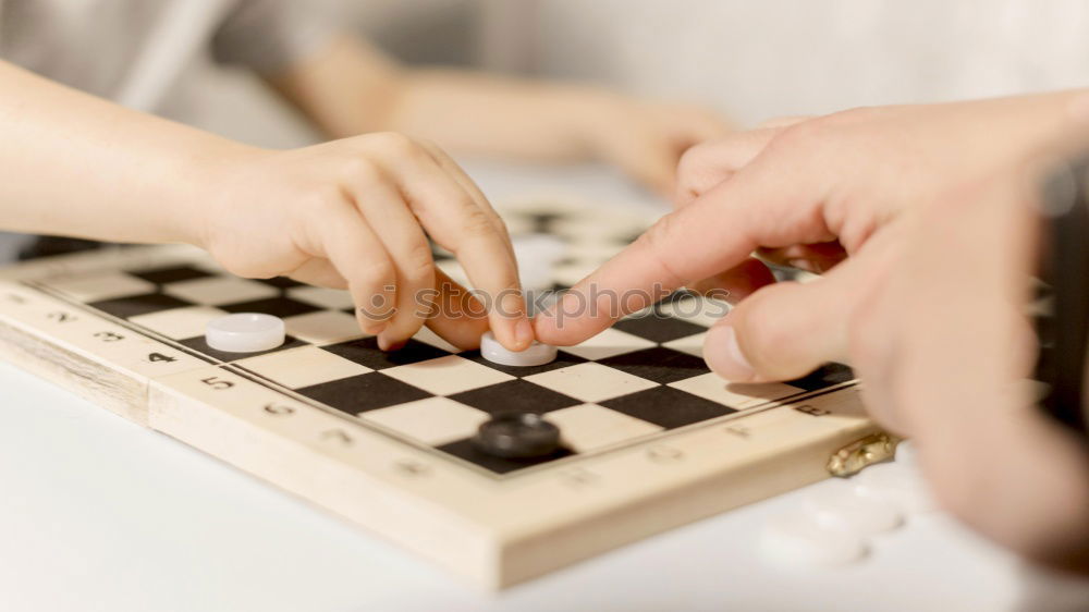 Girl and boy playing chess at home.