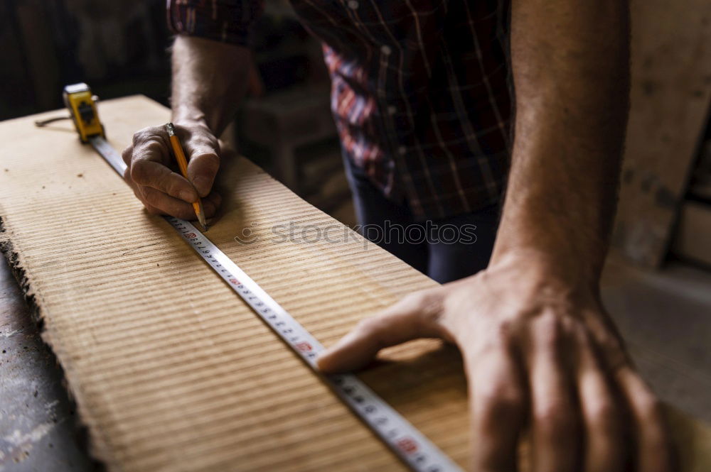 Similar – Carpenter with circular saw cutting a wooden plank