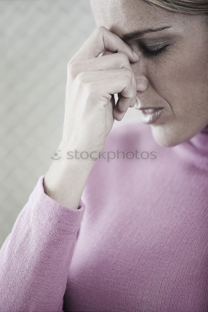 Similar – one sad woman sitting near a wall and holding her head in her hands