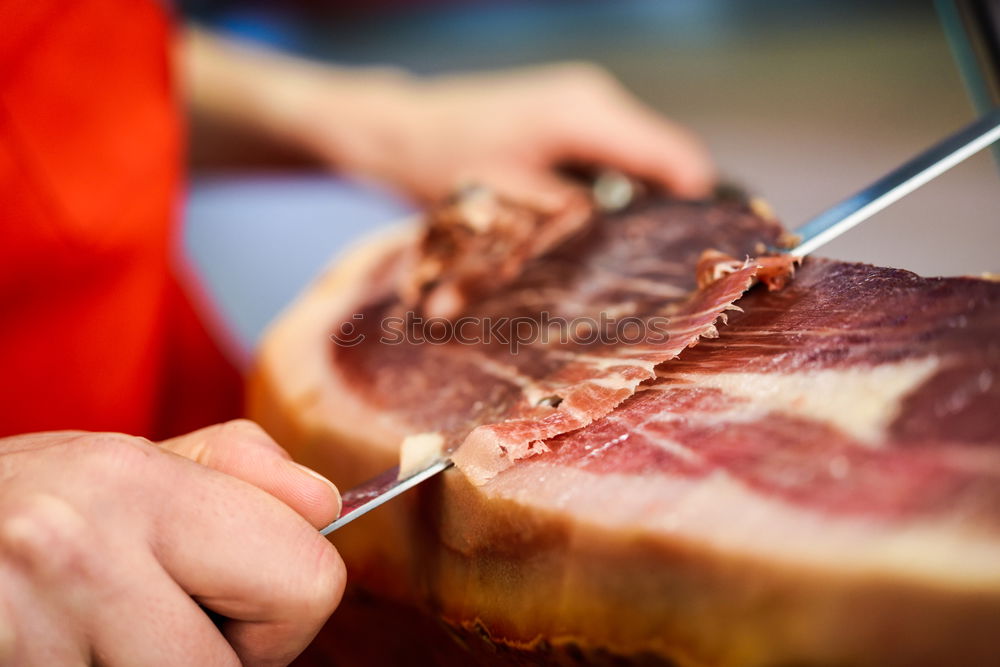 Similar – Image, Stock Photo Cutter carving slices from a whole bone-in serrano ham