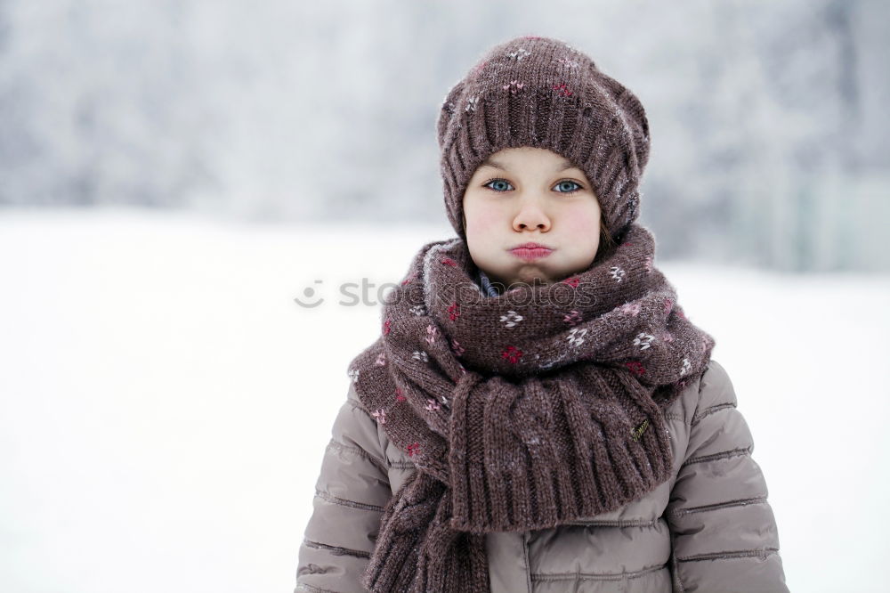 Similar – baby girl in knitted scarf walking in winter forest