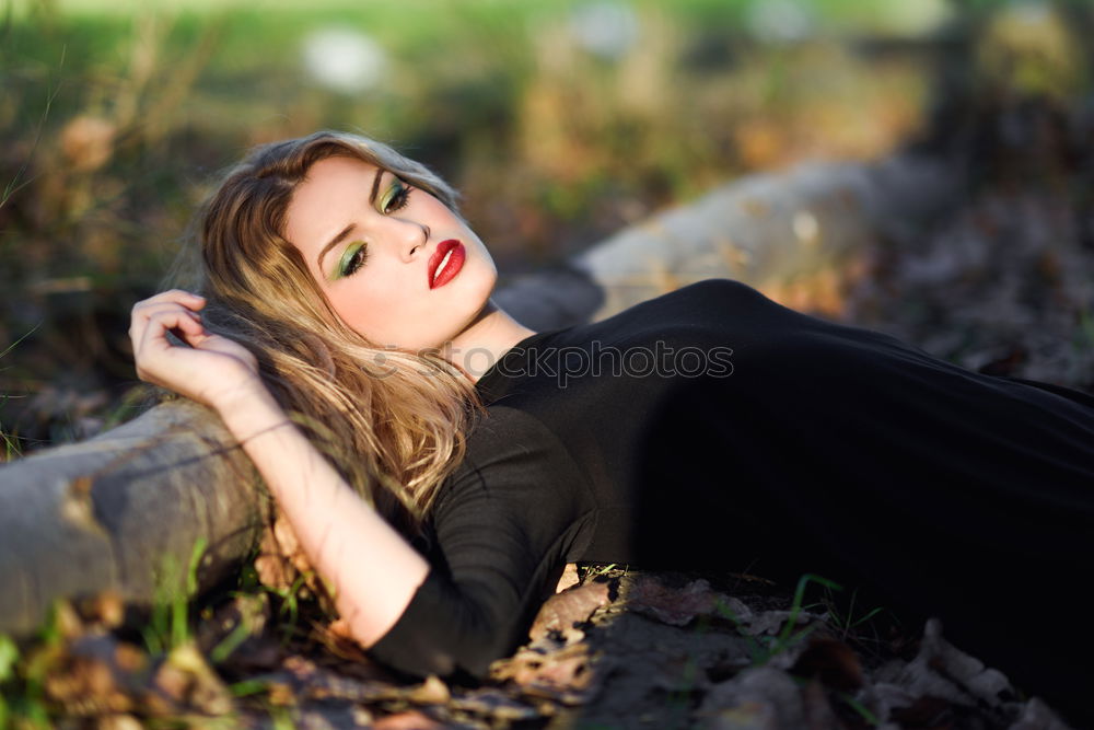 Relaxed girl lying on the field with long curly hair