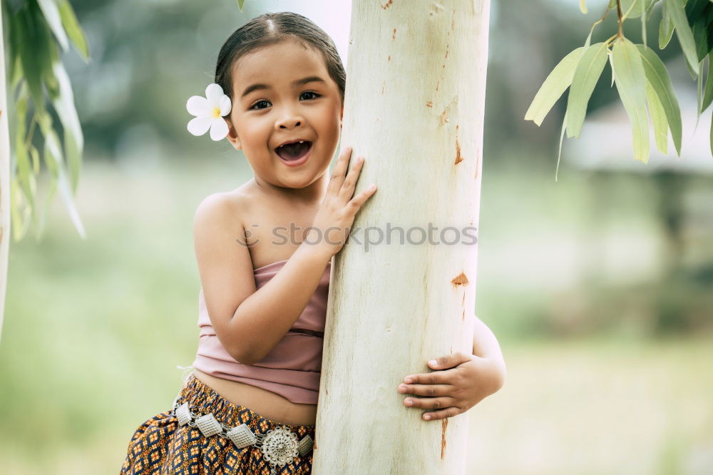 Cute black boy having fun on a swing in his parents garden