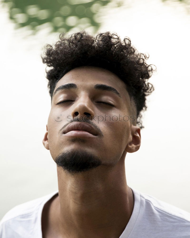 Similar – Portrait of a young thoughtful mixed race man sitting in the sofa