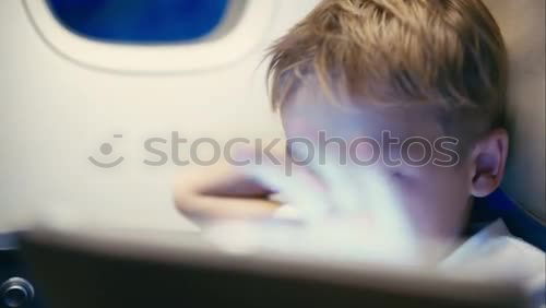 Similar – Image, Stock Photo Little boy sitting in his seat during a flight and painting on a tablet computer in an airplane