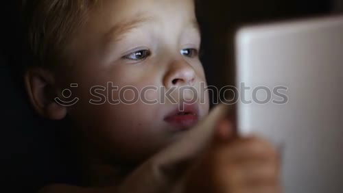 Similar – Image, Stock Photo Little boy sitting in his seat during a flight playing contentedly with a tablet computer in an airplane watched by his mother