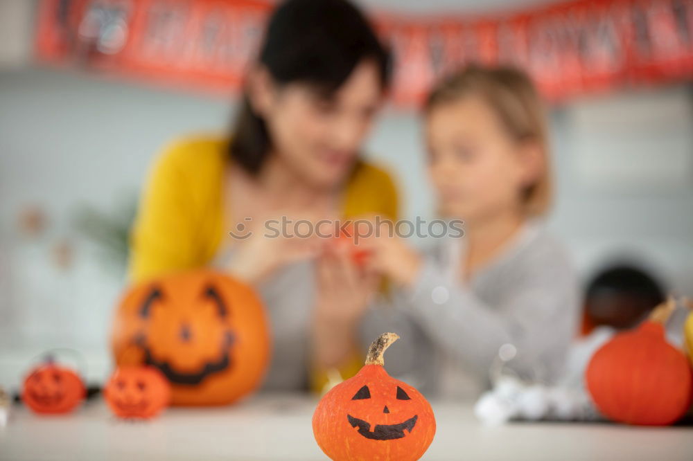 Similar – Image, Stock Photo Happy children disguised decorating a pumpkin at home.