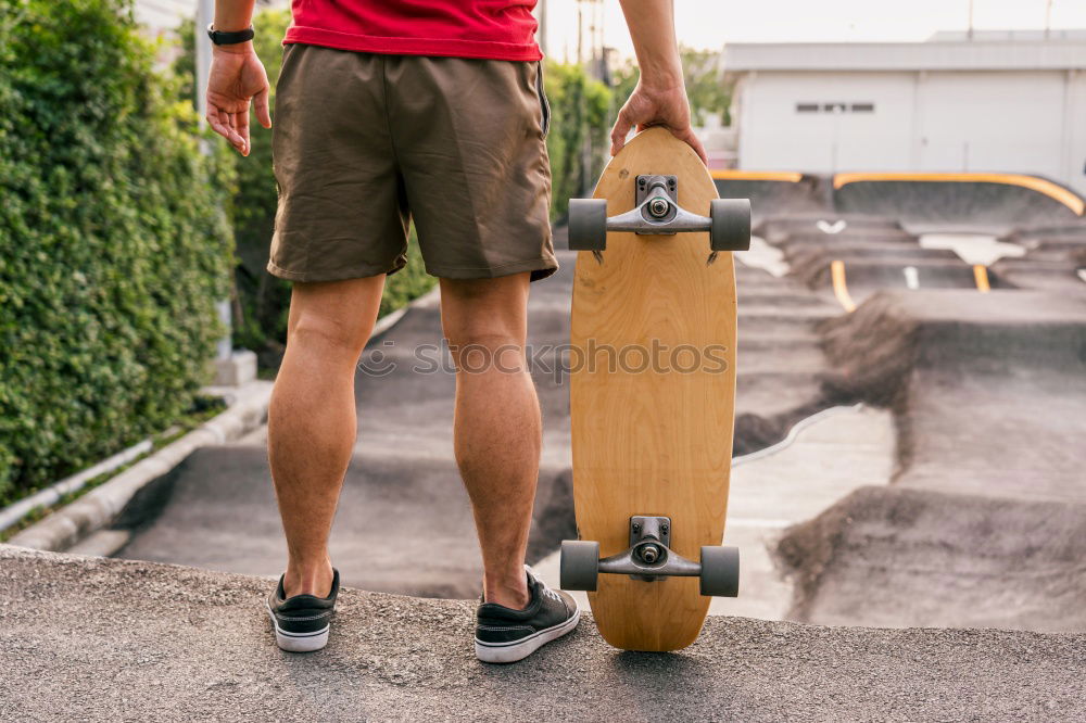 Similar – Man with tattoos holding skateboard at shore. Back view.