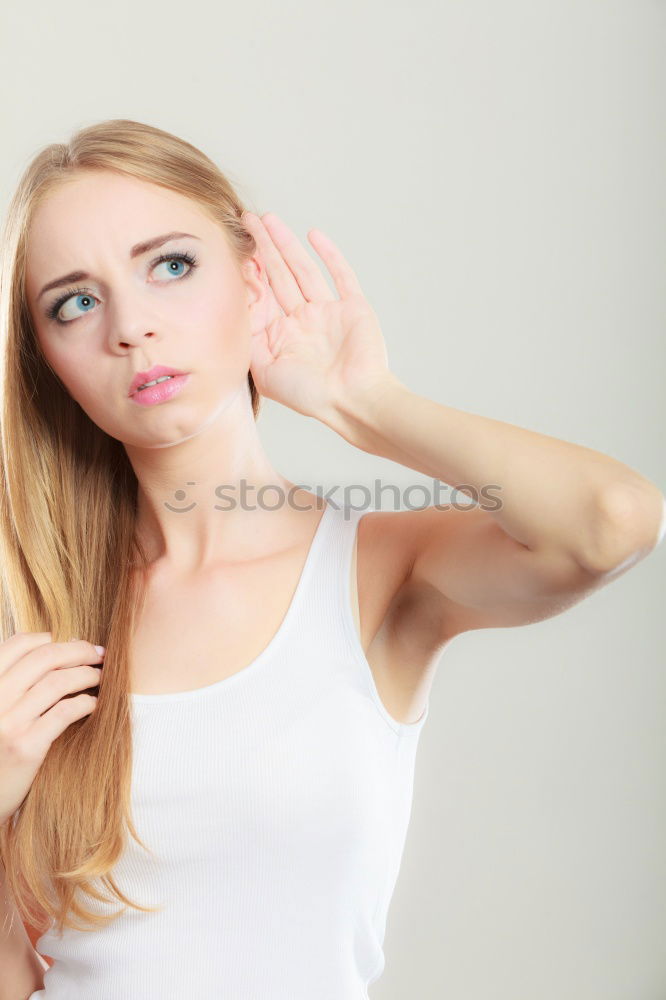 Girl with blonde hair posing in front of turquoise background