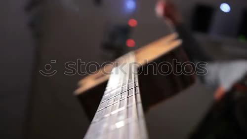 Similar – Image, Stock Photo A black electric guitar on a wooden board table photographed from the guitar head perspective. The focus is on the side holder and knob.