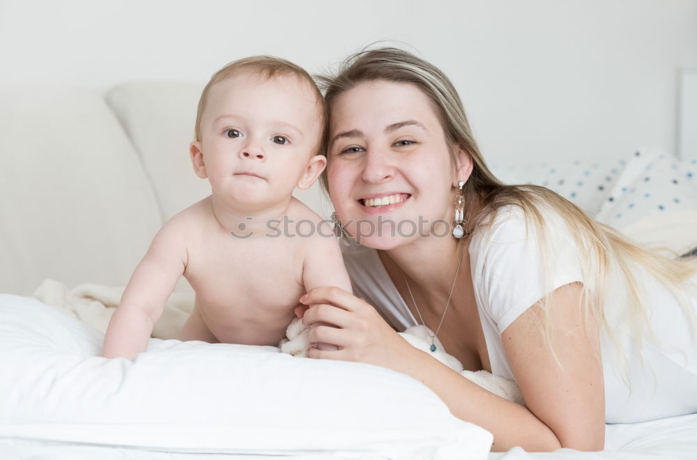 Similar – happy young mother and her baby boy lying on bed and smiling