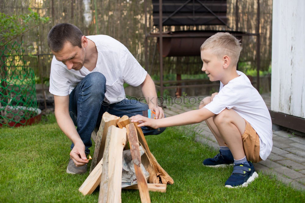 Similar – Image, Stock Photo Cheerful young man teaching his son to play mini golf