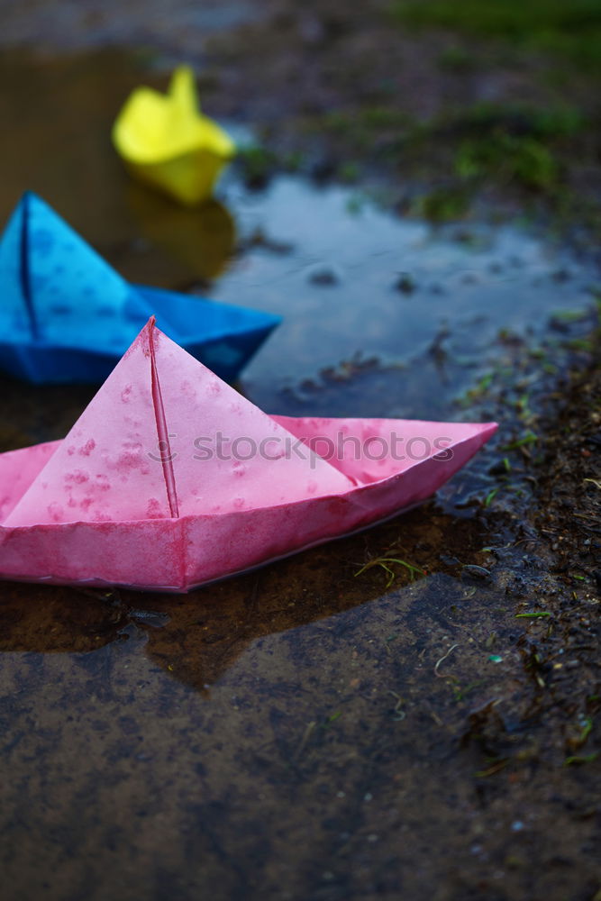 Similar – Color paper boats in a rainy day