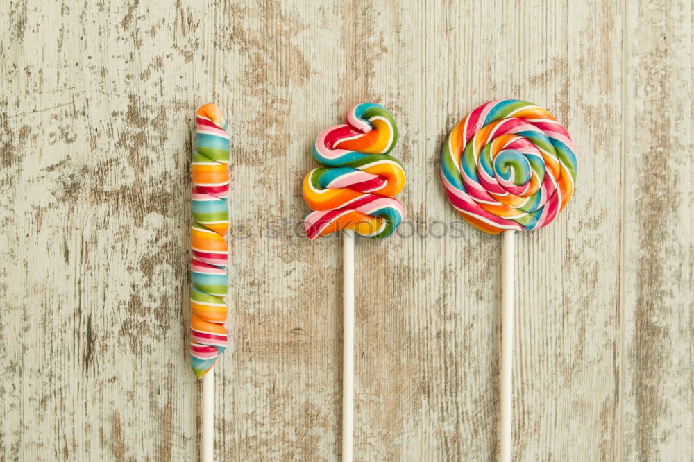 Similar – Woman hand holding three colorful lollipops