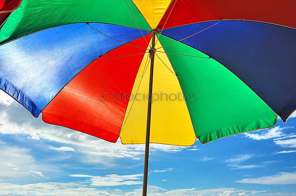 Similar – Rain on umbrella in rainbow colors under heavy rain against background of cloudy sky. Rainy weather concept.