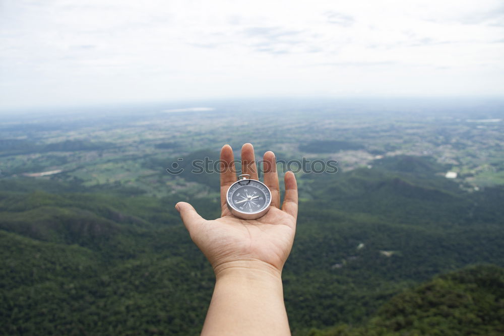 Image, Stock Photo Hand with compass at mountain road at blue sky