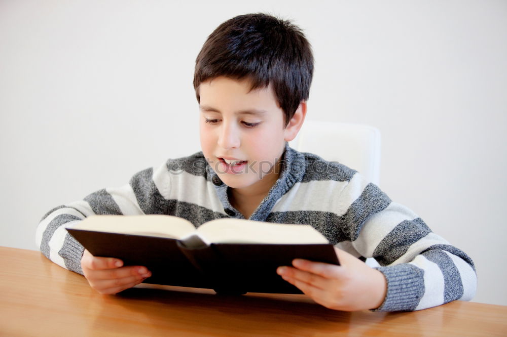 Similar – boy reading books on gray background