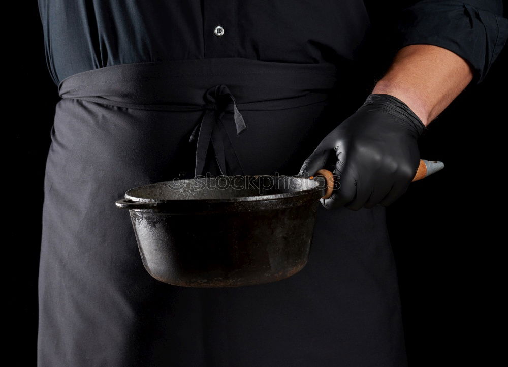 Similar – cook in red uniform holding an empty black frying pan