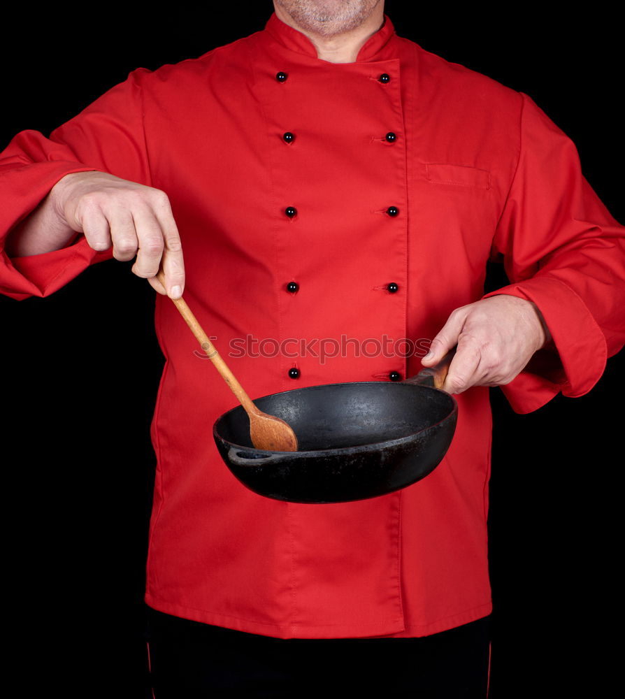 Similar – cook in red uniform holding an empty black frying pan