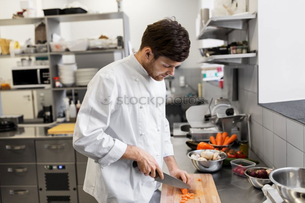 Similar – Image, Stock Photo A cook in a restaurant wearing a mask as a precaution against the coronavirus preparing the meal.