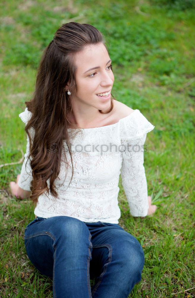 Similar – Stylish smiling teenager sitting on the ground in a city park