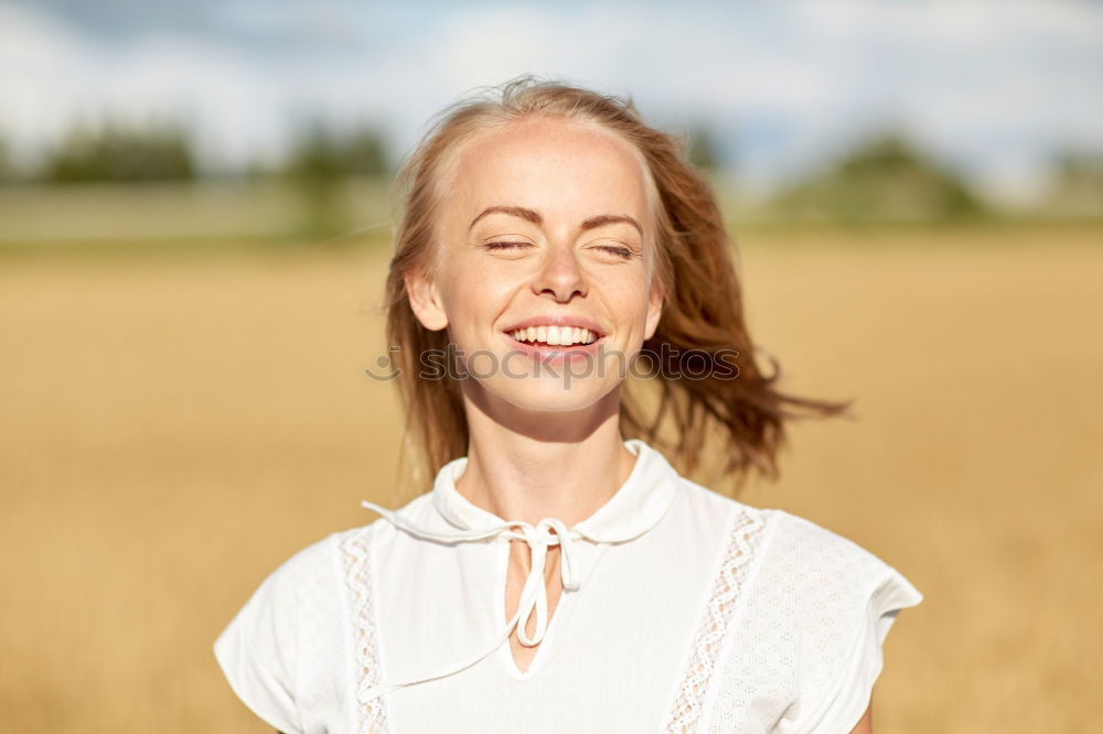 Image, Stock Photo Portrait of a smiling young woman with freckles standing in front of a field