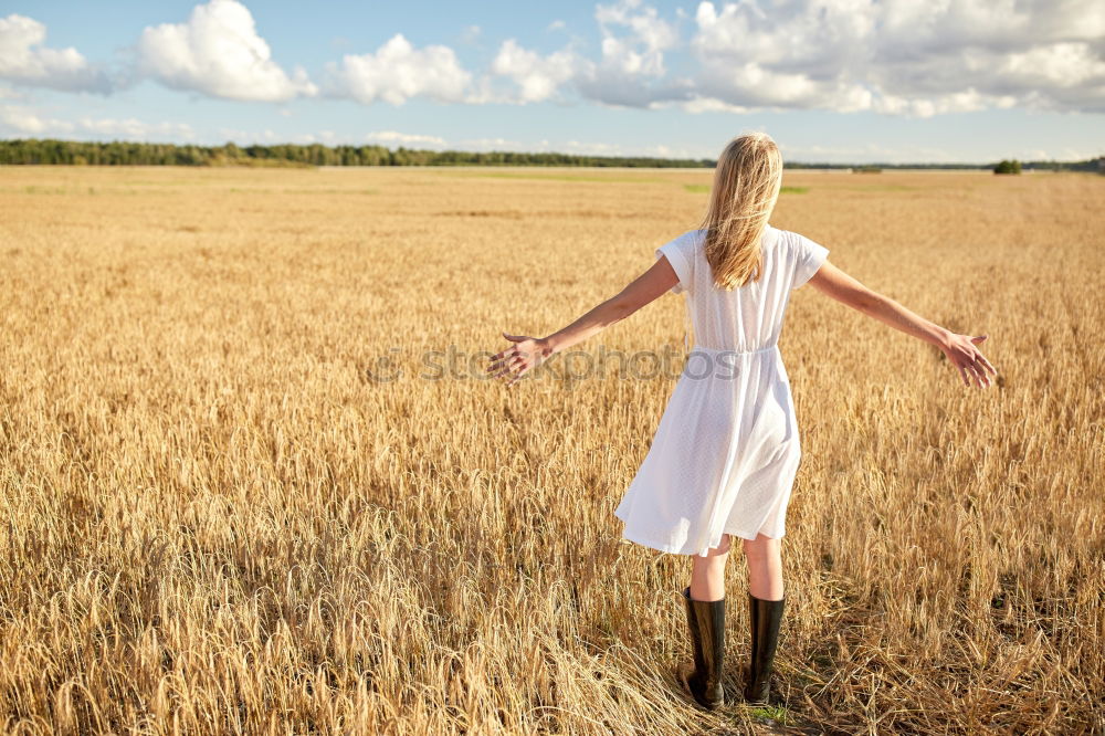 Similar – Hand holding a cowboy hat over a field of wheat